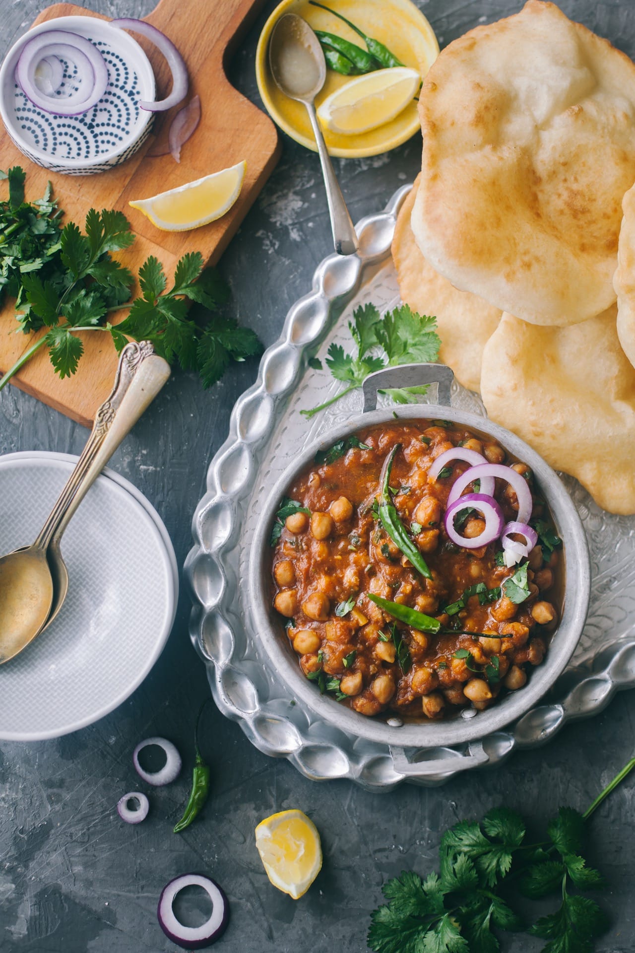 chana chola masala in a bowl with paratha on the side and salad - How to Style Curries