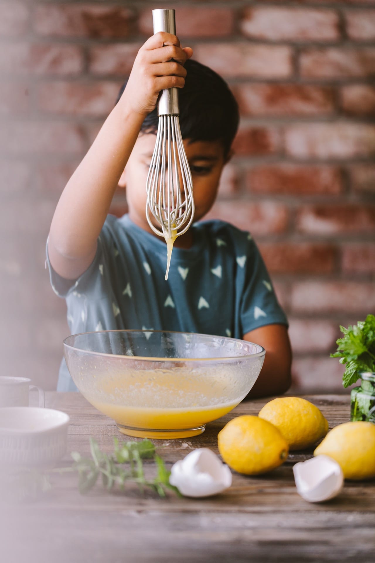 Little boy whisking egg in a mixing bowl