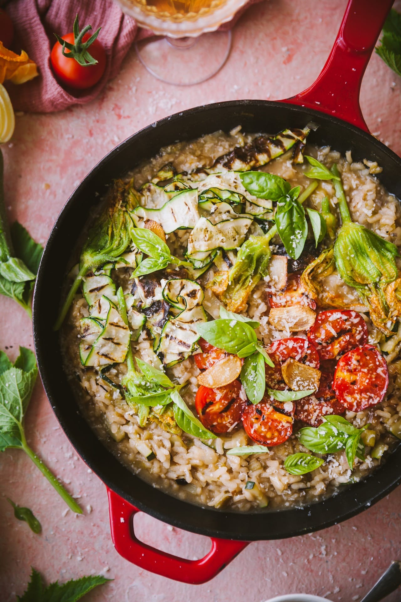 A pan filled with creamy rice and fresh summer vegetables.