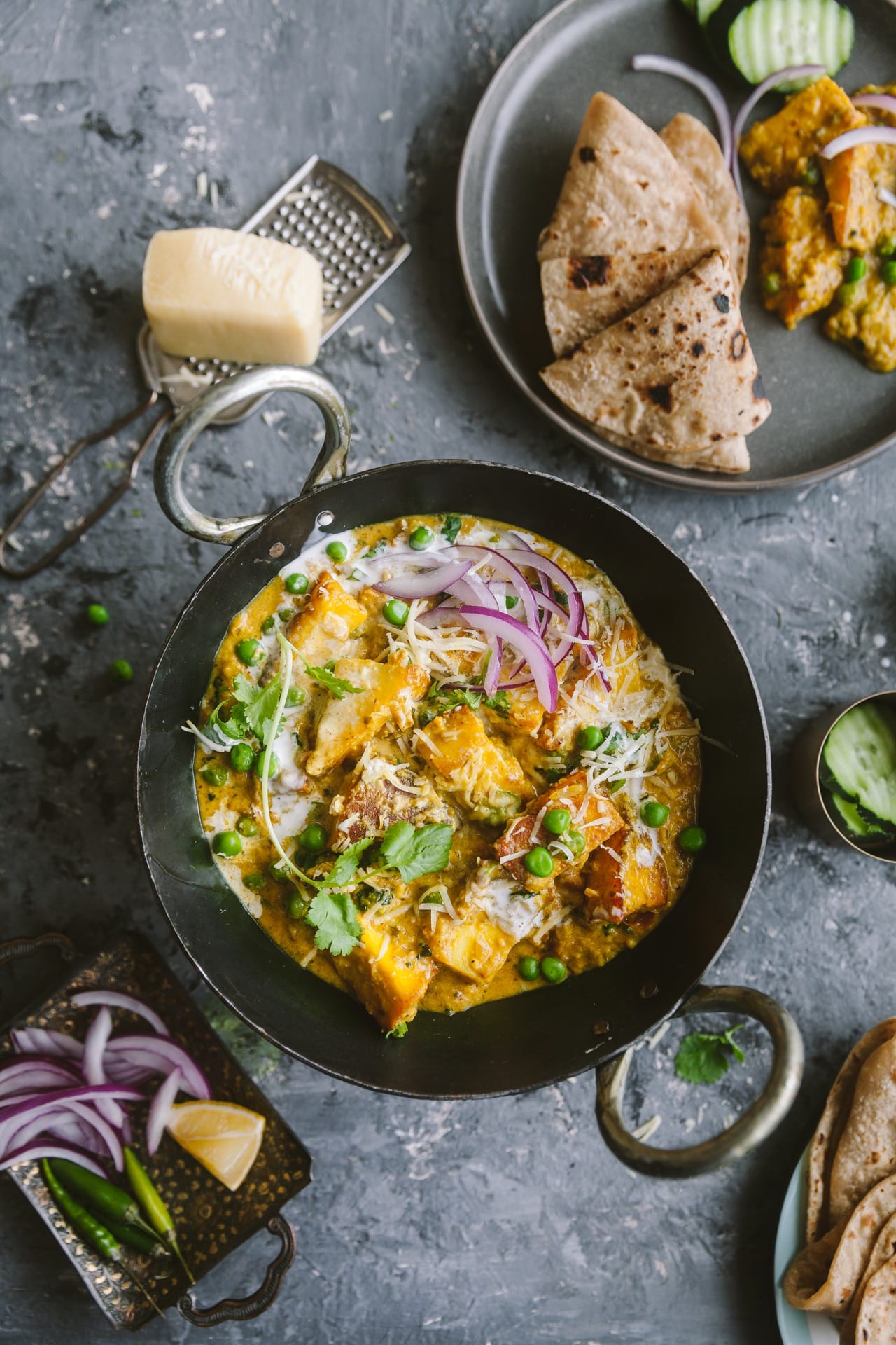 Flat lay overview of khoya matar paneer with paratha on the side