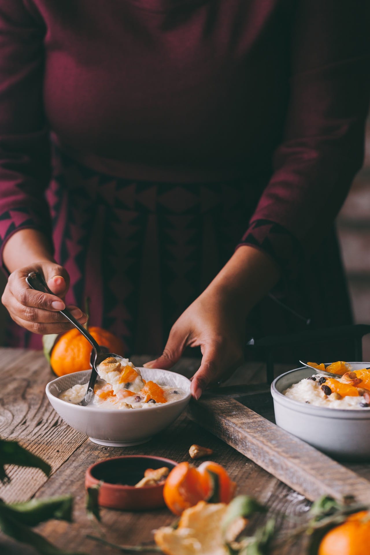 Hands in frame enjoying orange rice pudding.
